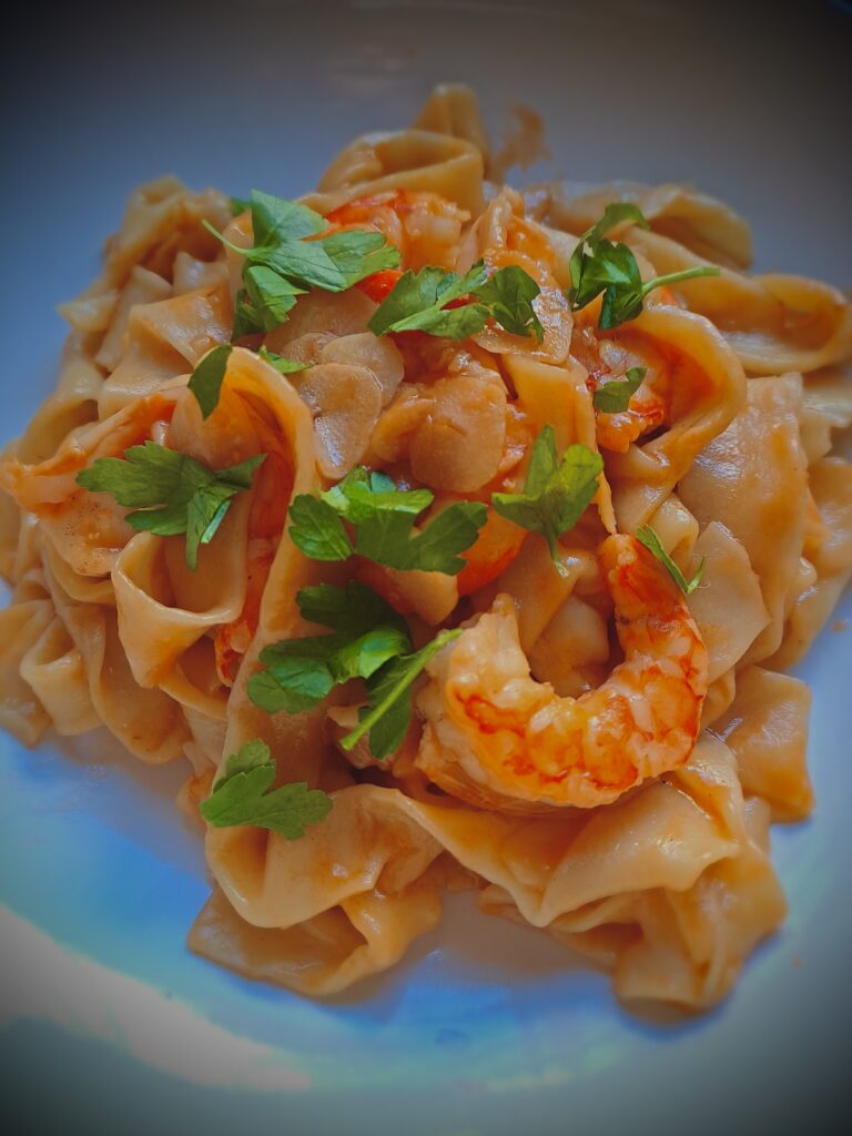 Self-made pasta with shrimp, garlic and parsley